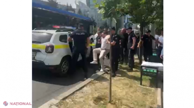 VIDEO // Omul lui Șor, luat pe sus de polițiști în preajma Judecătoriei Chișinău, sediul Buiucani. Liderul „Șansă” a dat cu picioarele în mașina Poliției